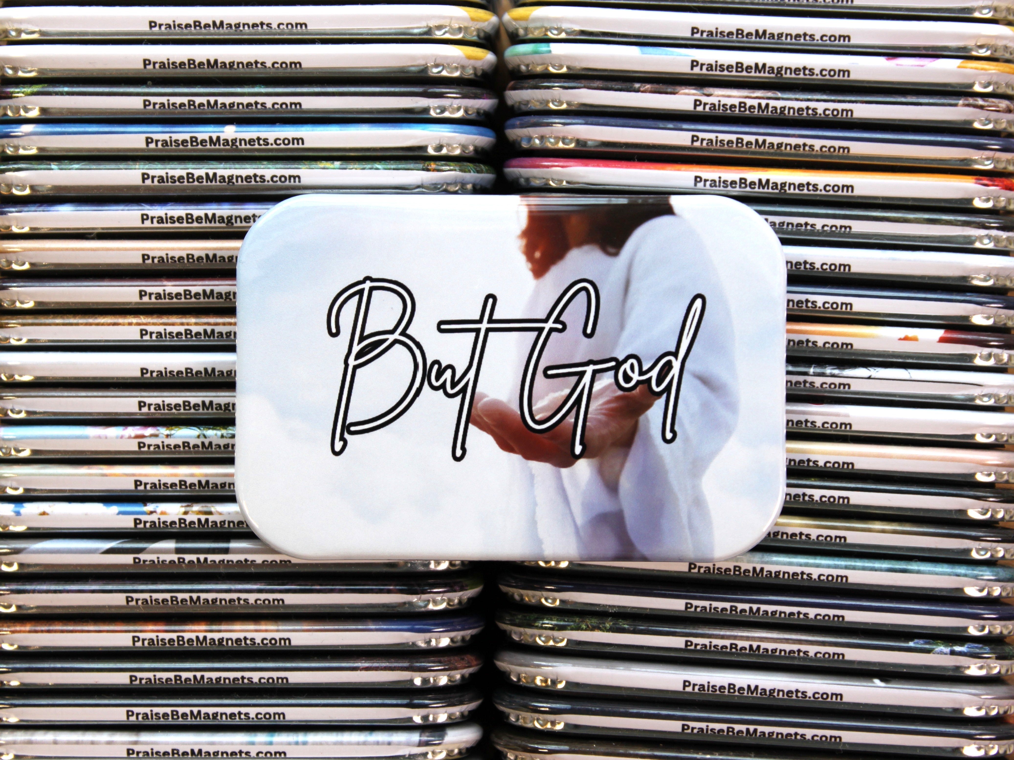 Stack of metal magnets with a central magnet featuring 'But God' text and an image of a person.