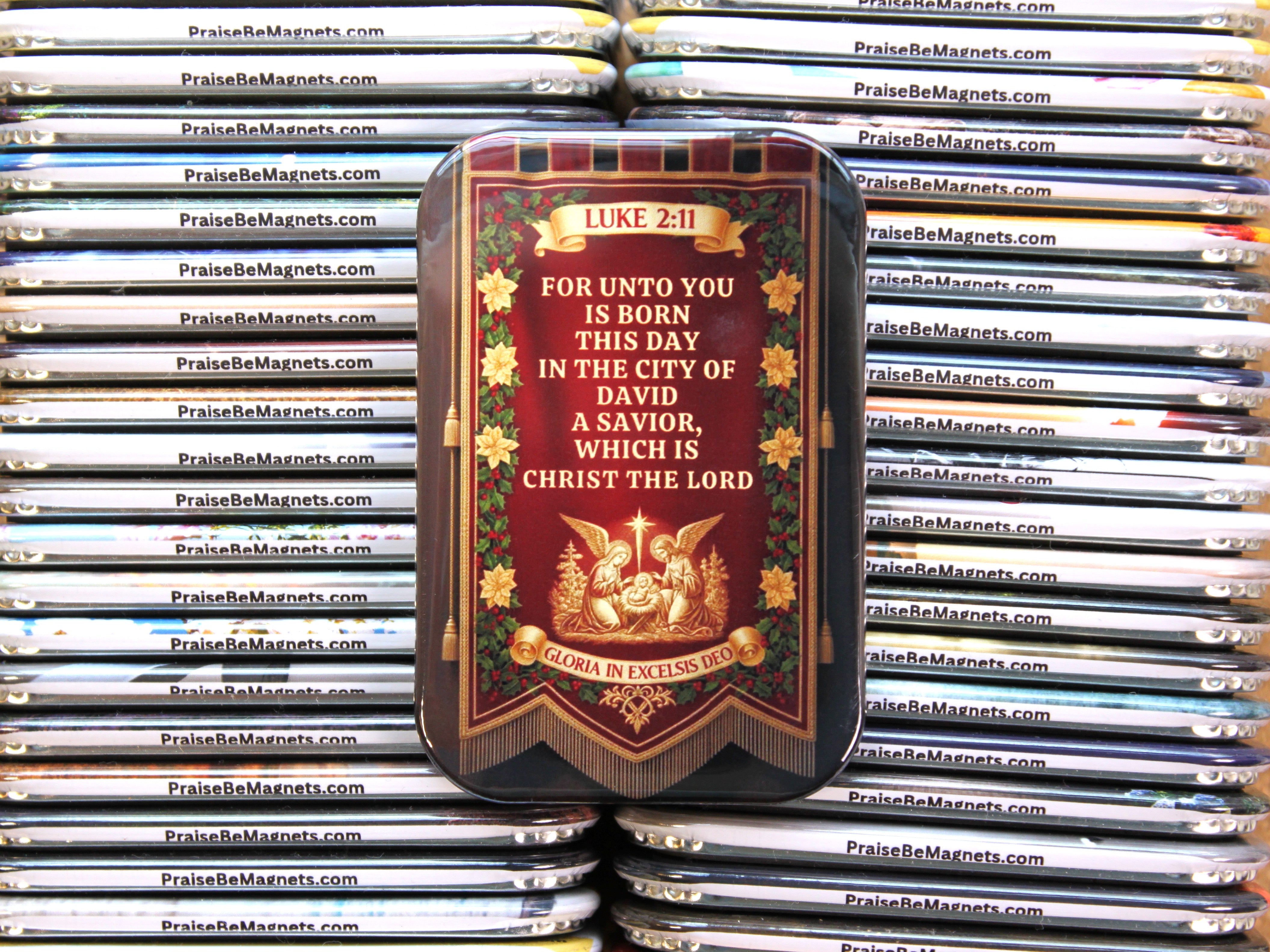 Decorative magnet with religious text and imagery on a stack of similar magnets.