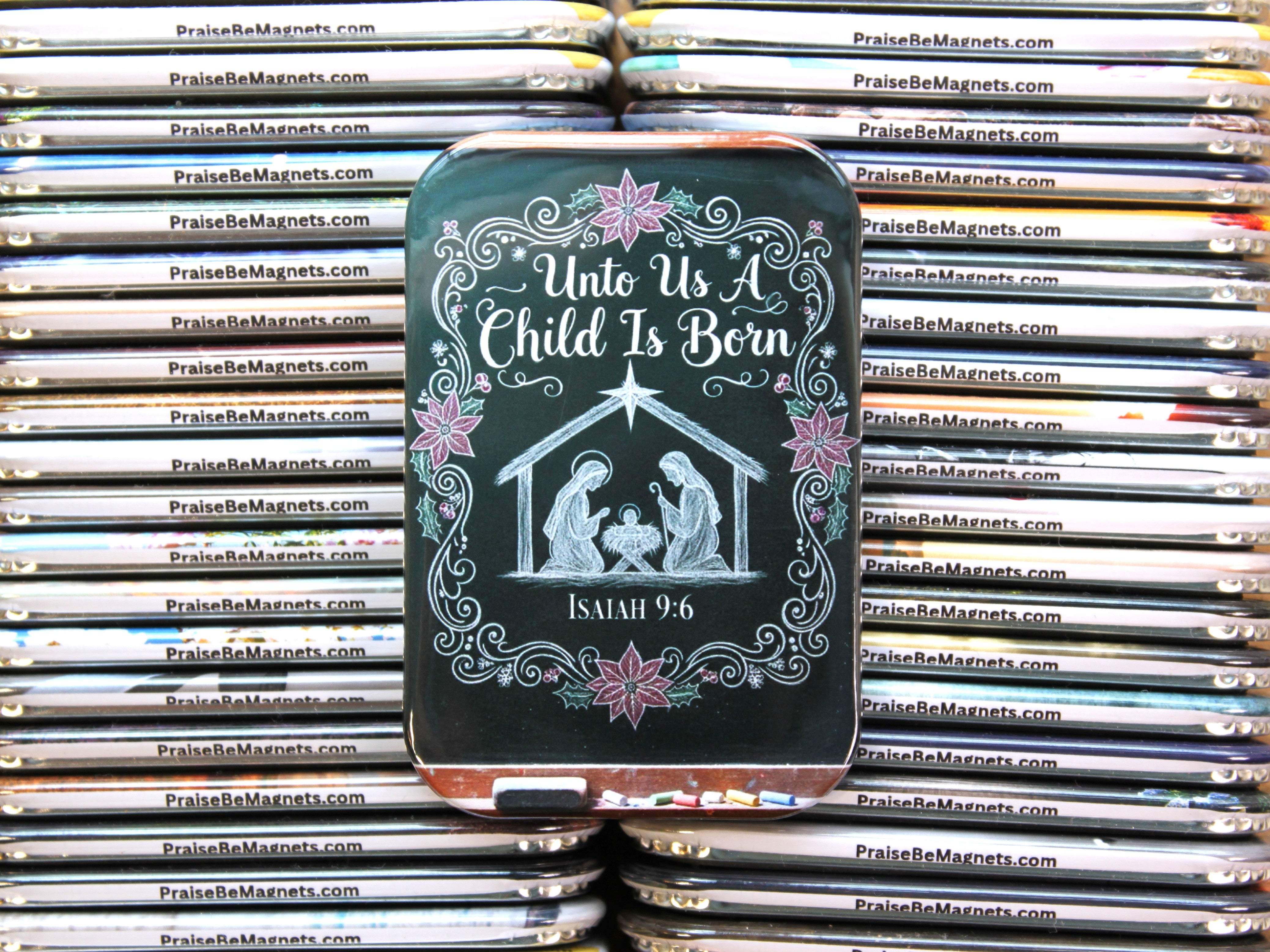 Tin with nativity scene design and 'Unto Us a Child Is Born' text, surrounded by stacks of similar tins.