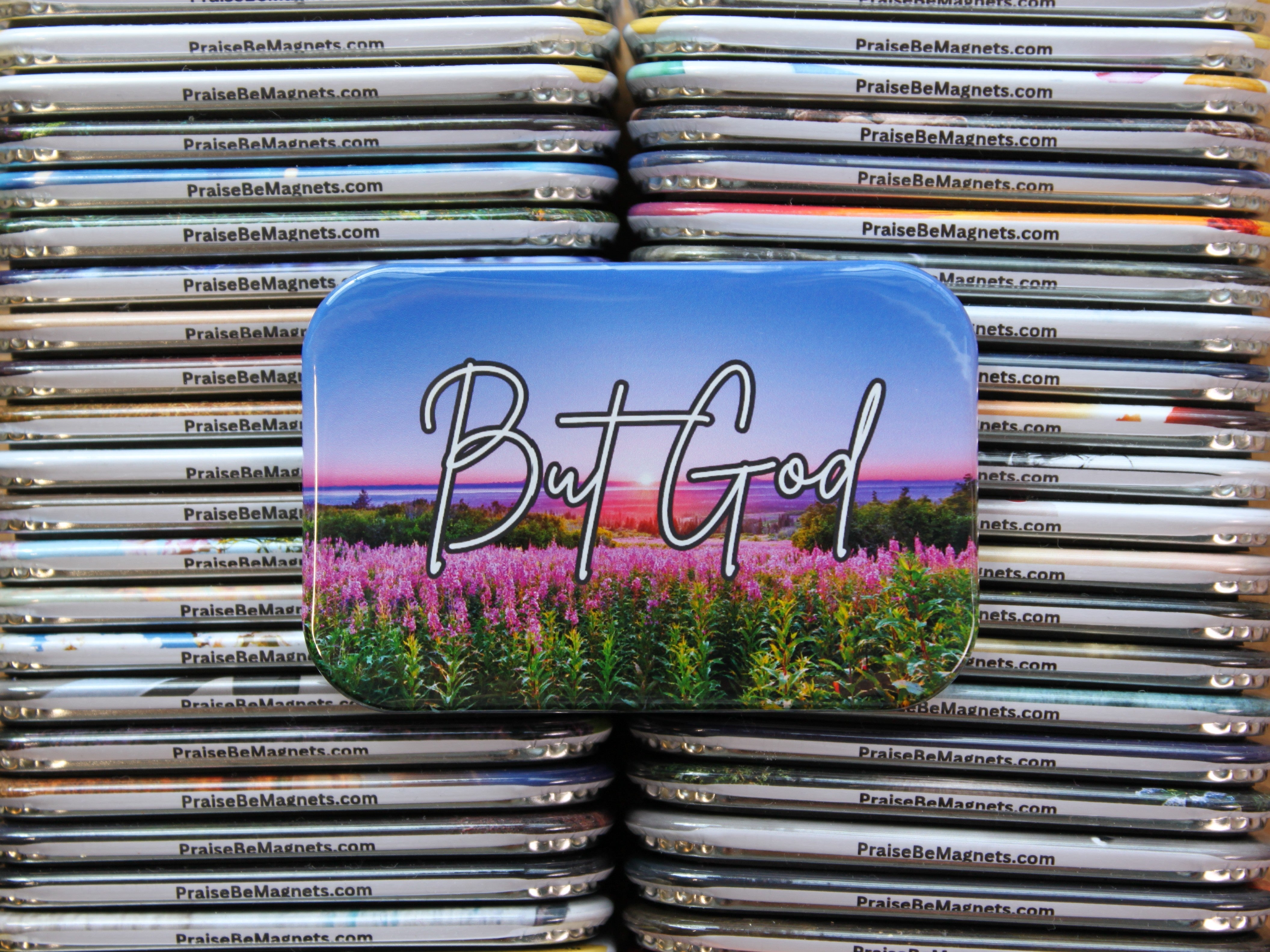 Stack of magnets with a colorful design featuring 'But God' and a landscape.