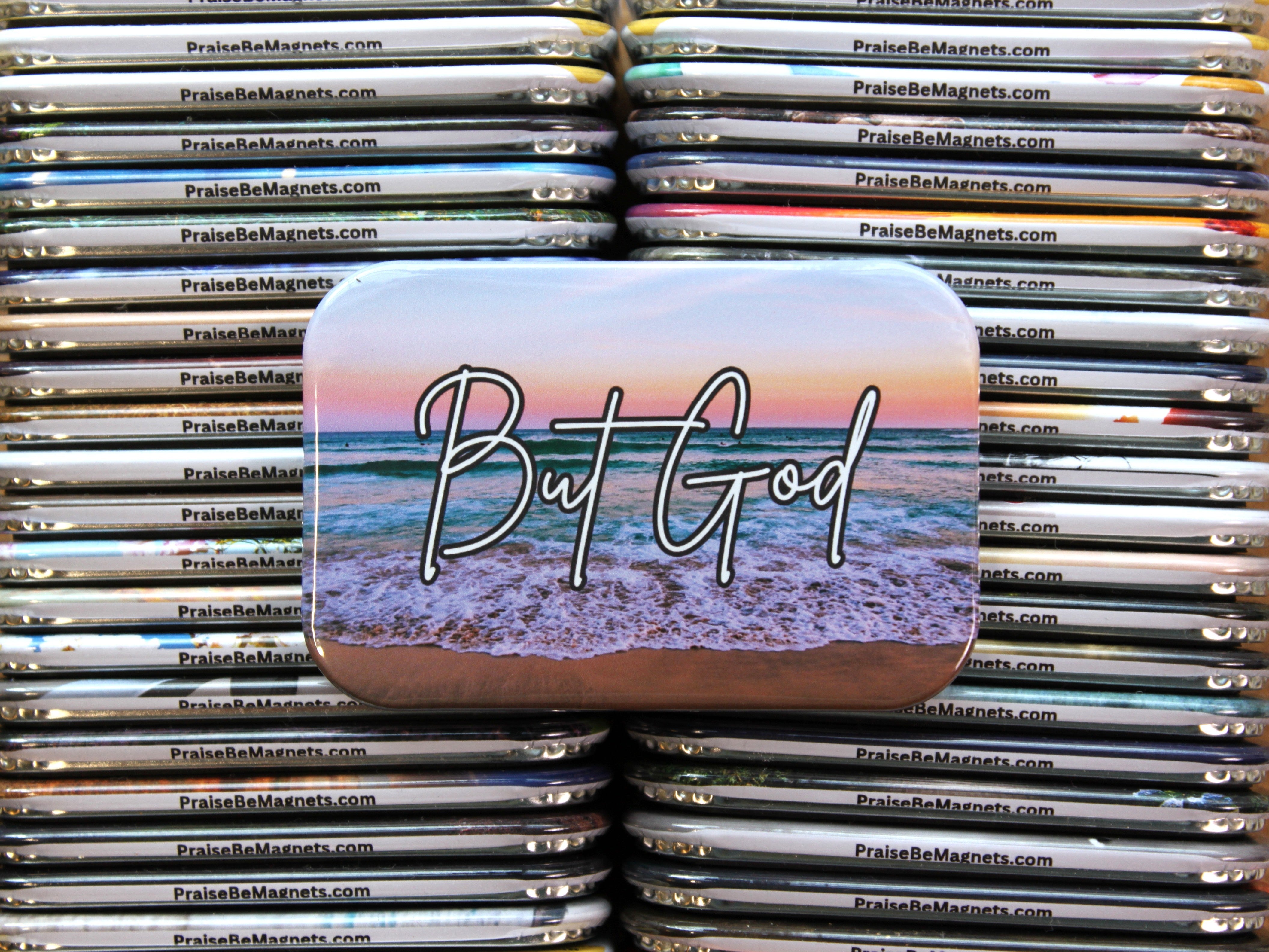 Stack of 'But God' beach-themed magnets with a website address.