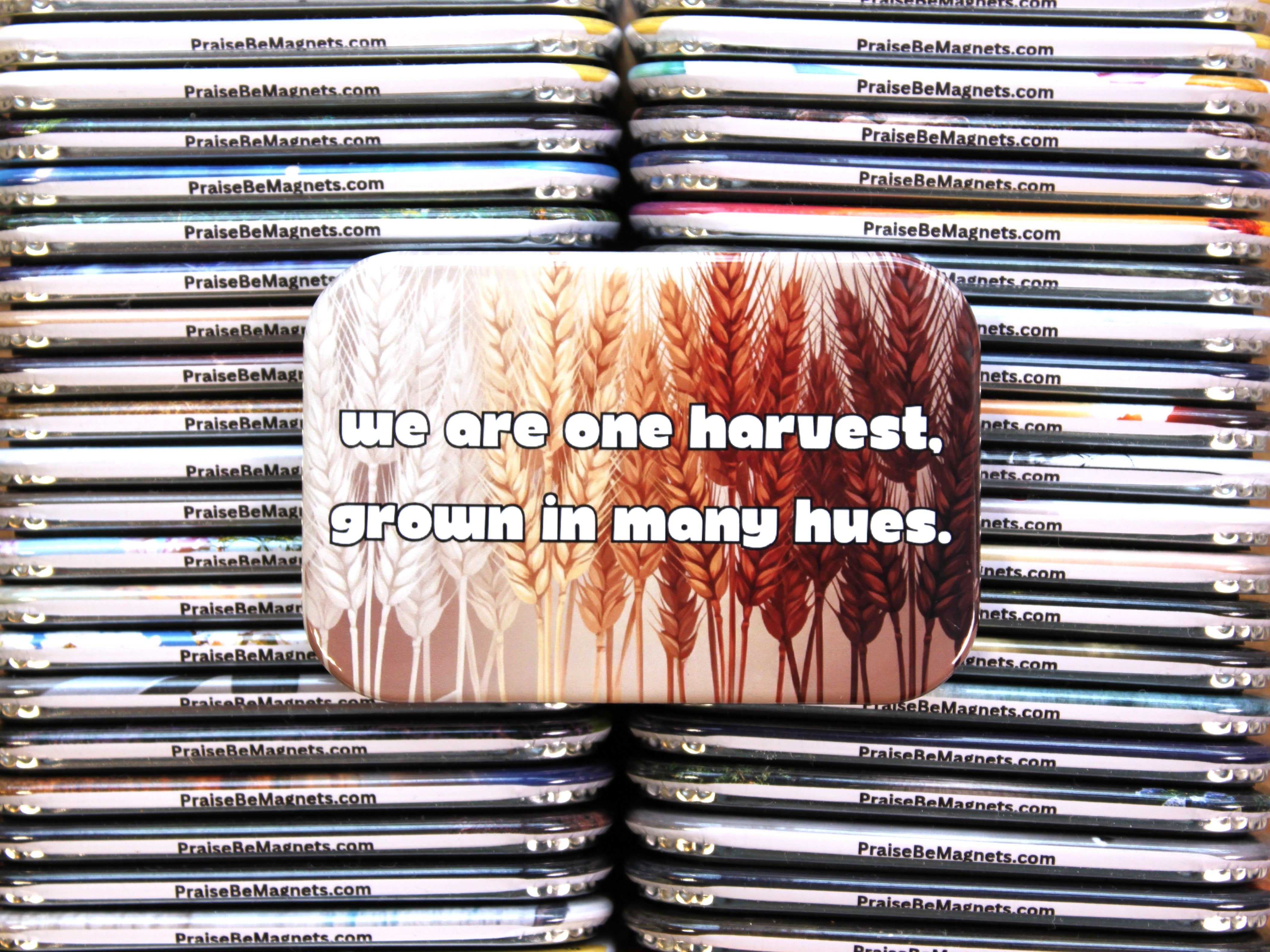 Stack of magnets with a central magnet featuring wheat design and text 'we are one harvest, grown in many hues.'