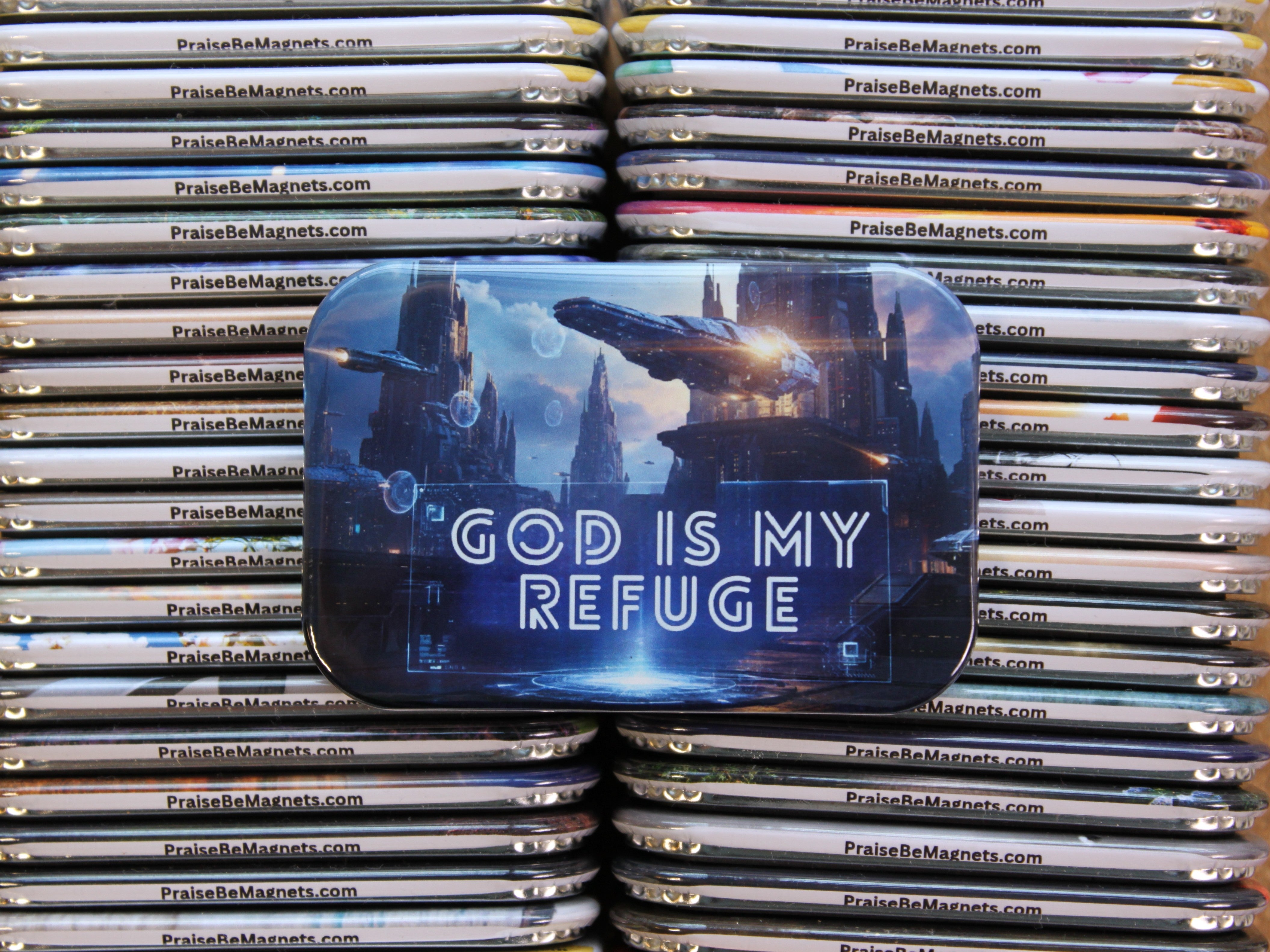 Stack of 'Praise Me Magnets' with a prominent magnet displaying 'God is my Refuge'.