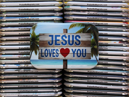 Stack of 'Jesus Loves You' magnets with palm trees on a metal surface.