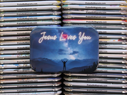 Stack of 'Praise Be Magnets' with a prominent 'Jesus Loves You' tin in the foreground.