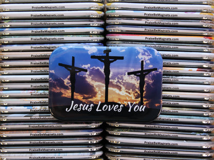 Stack of 'Praise Be Magnets' with a central magnet featuring 'Jesus Loves You' text and crucifixion imagery.