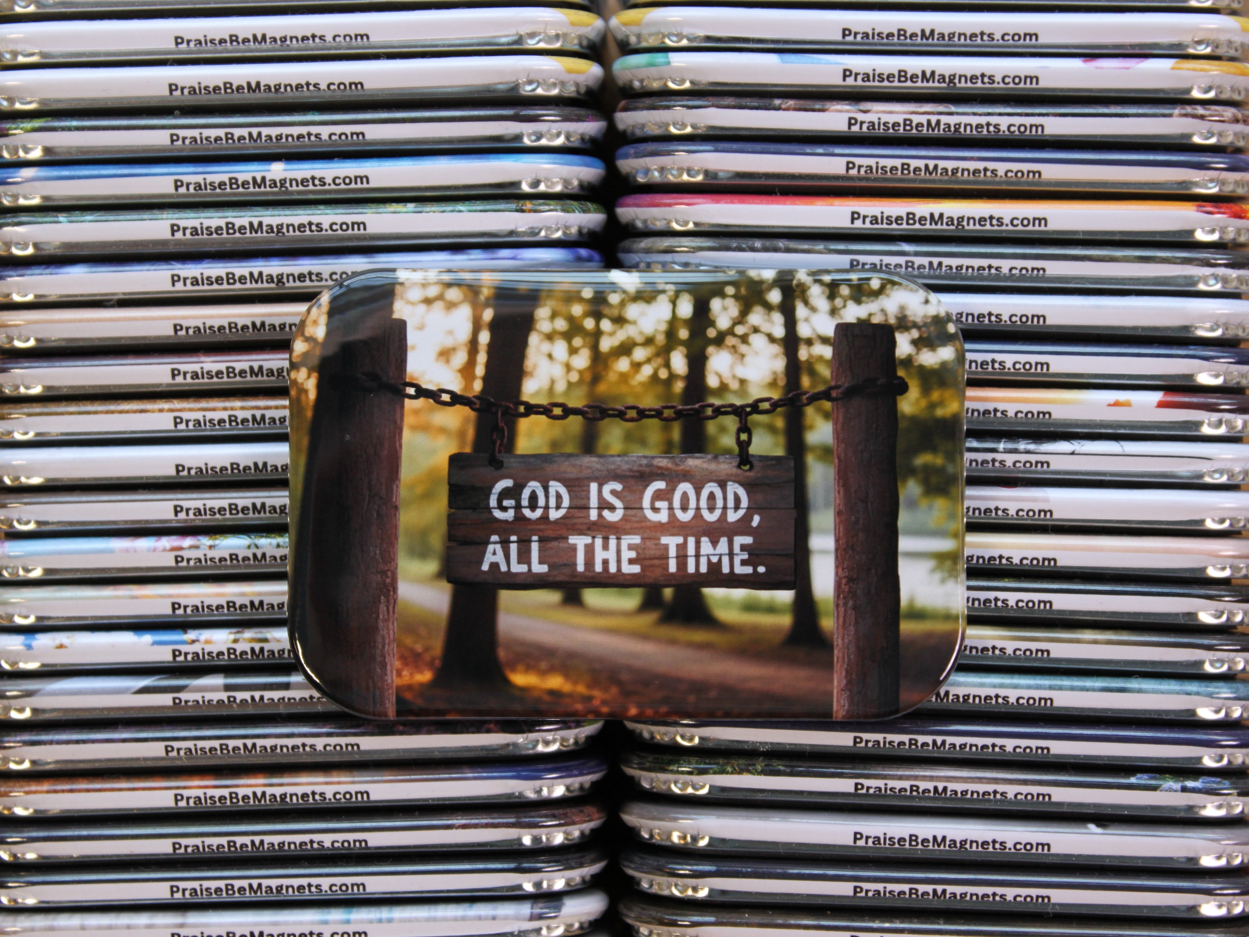 Stack of 'PraiseBeMagnets' with a magnet featuring 'God is Good, All the Time.' text.