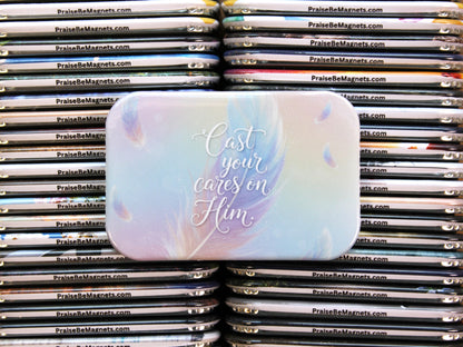 Stack of 'Praise Be' magnets with a prominent magnet in the foreground featuring text.