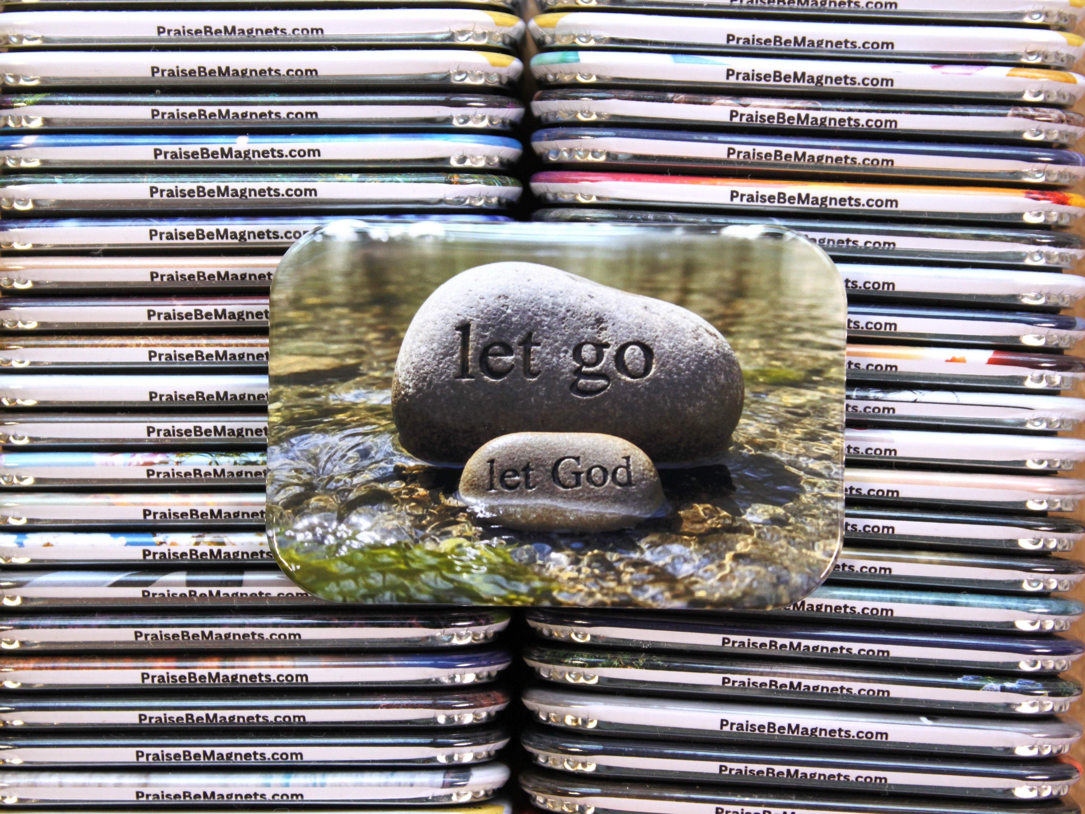 Stack of 'PraiseBeMagnets' with a central magnet featuring stones with 'let go' and 'let God' text.