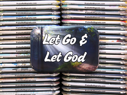 Stack of metal containers with 'Let Go & Let God' text on a reflective surface.