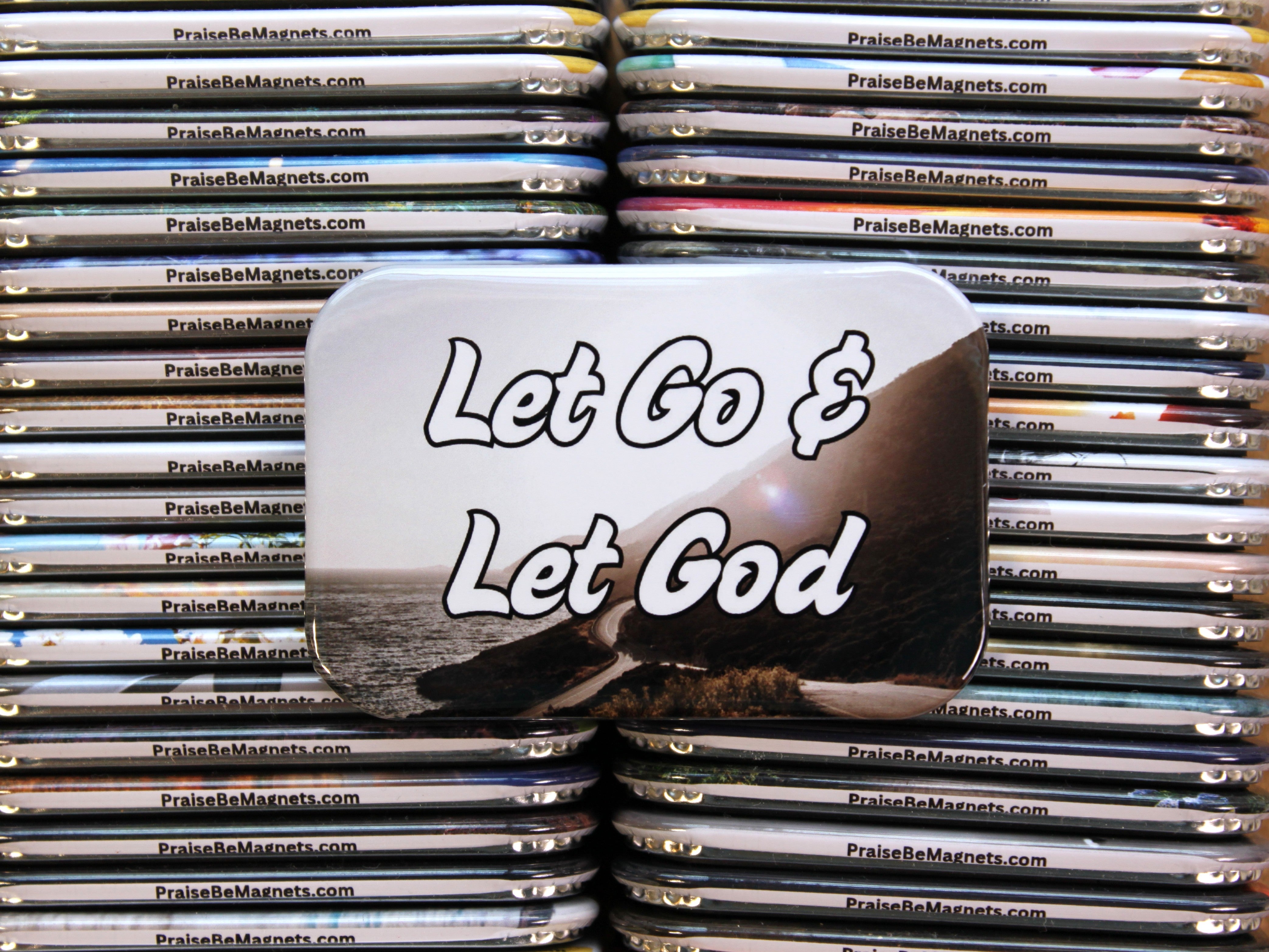 Stack of 'Let Go & Let God' magnets with a website address on a white background