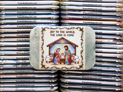 Stack of Christmas-themed magnets with a nativity scene design on a tin.