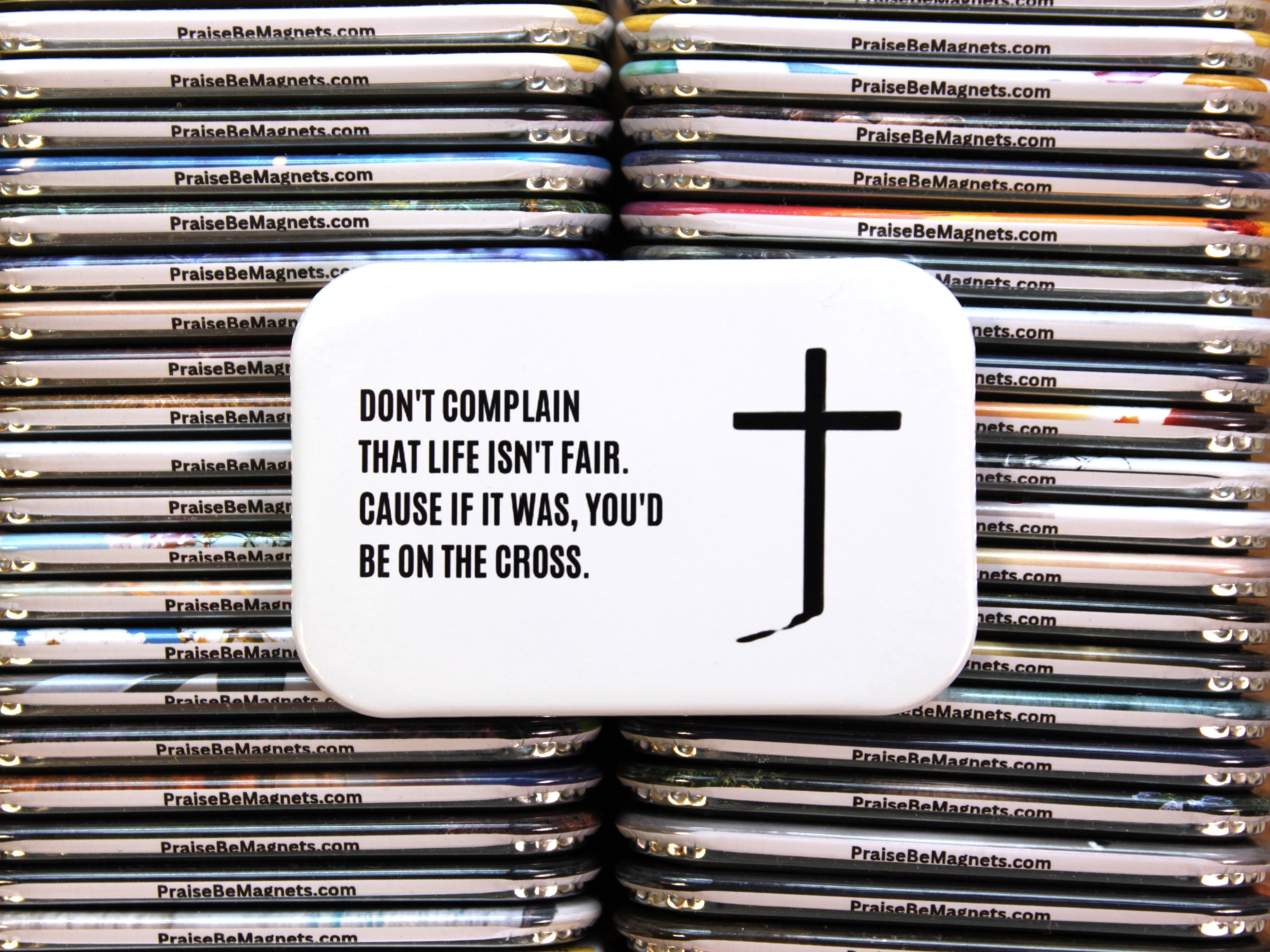Stack of magnets with a cross and motivational quote on a white background