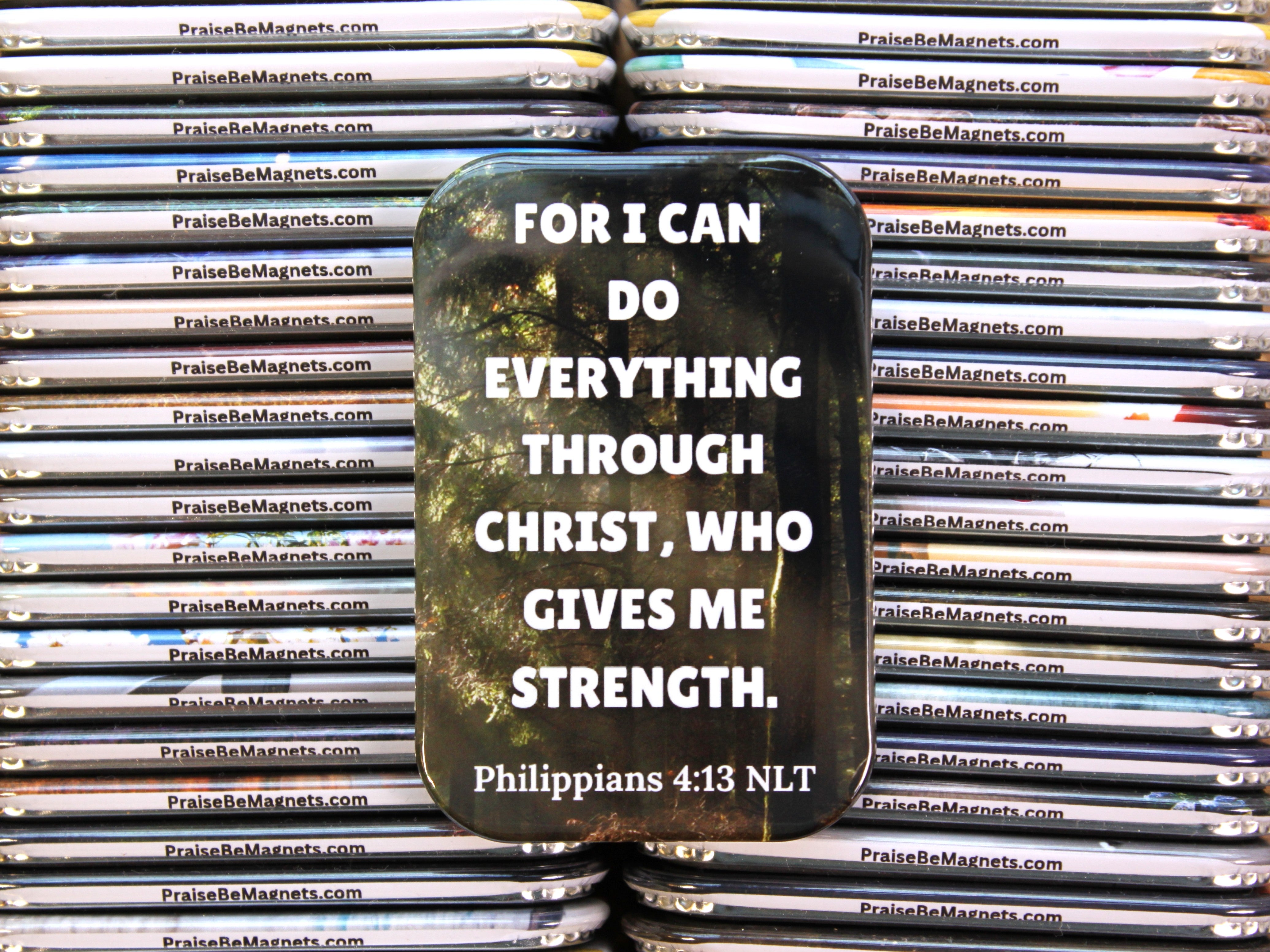 Stack of metal magnets with a motivational quote on one magnet, branded 'PraiseBeMagnets.com'.