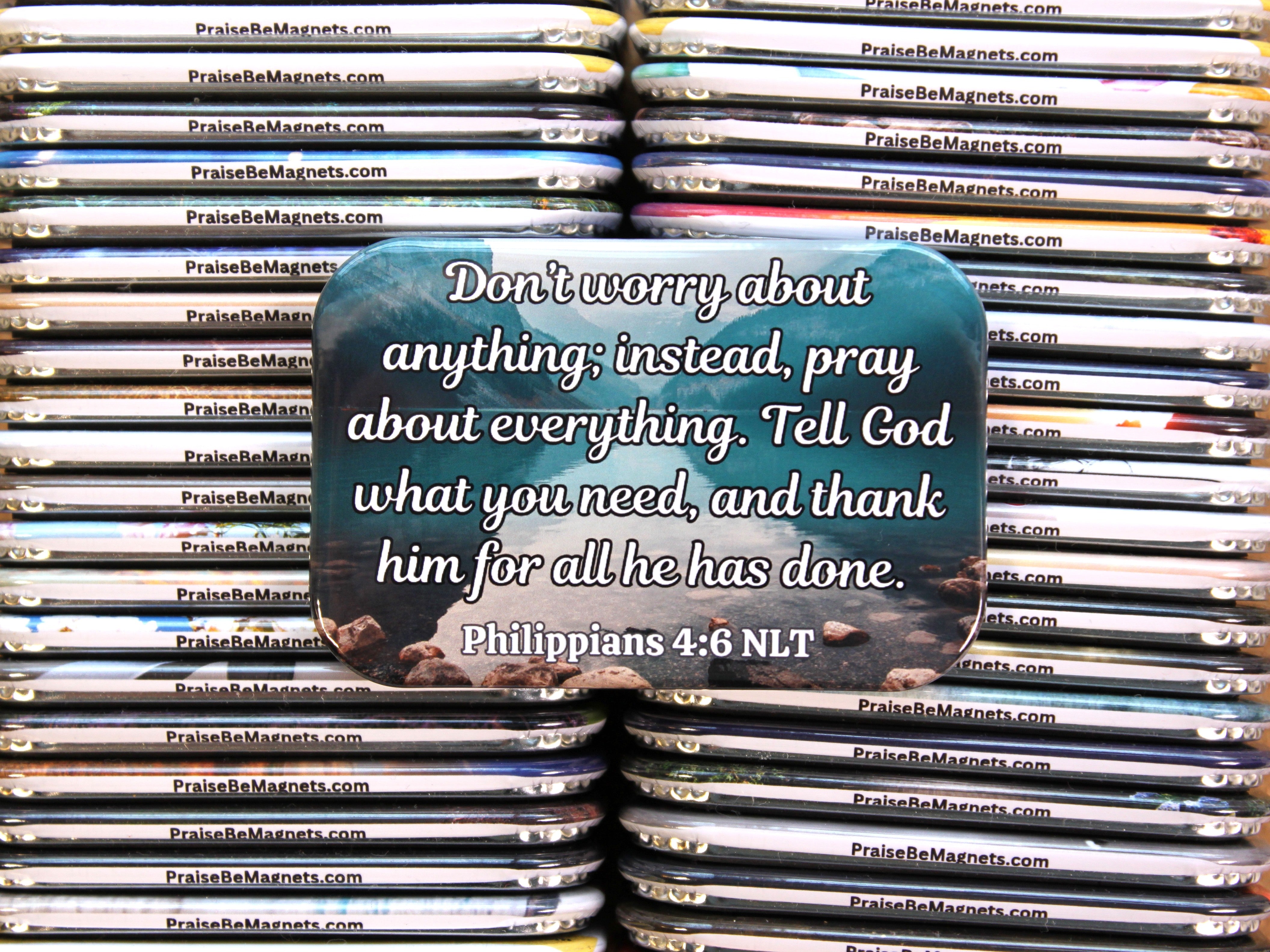 Stack of 'Praise Be' magnets with a central magnet featuringPhilippians 4:6 NLT text.