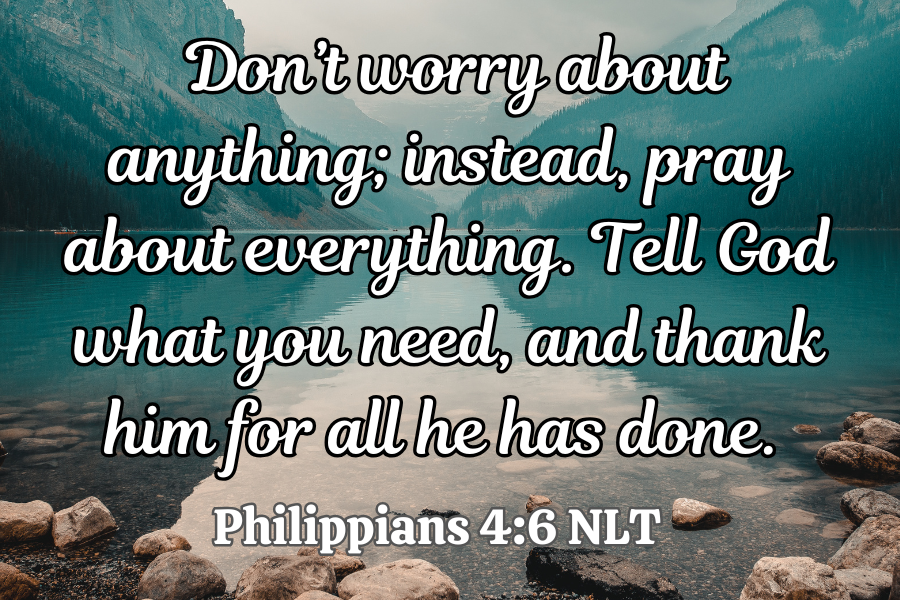 Philippians 4:6 NLT quote over a scenic background with mountains and water.